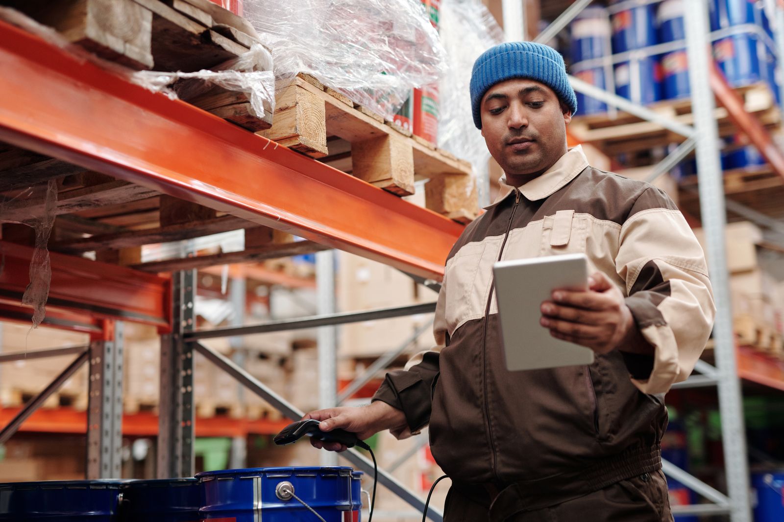 Warehouse employee using a tablet beside storage racks